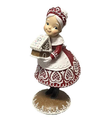 Red Gingerbread Mrs Claus Holding a Gingerbread House