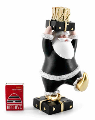 Blackand White Santa with Leg up Holding a stack of Gofts